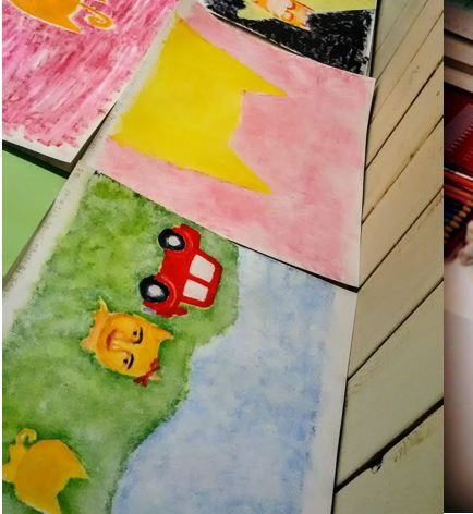赤いバスと風景を描いた子どもの水彩画